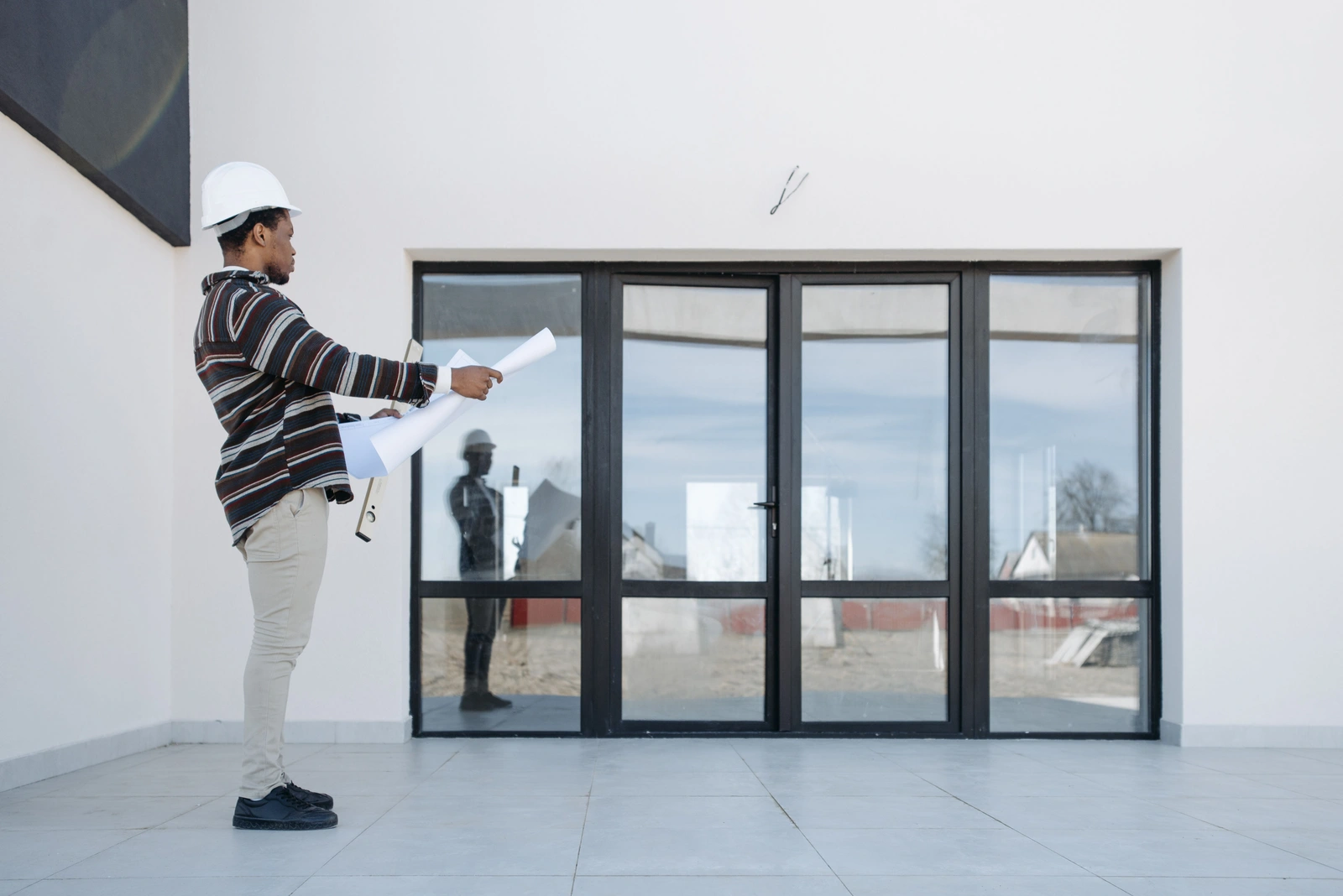 Architect reviewing full-scope construction plans on a new build site