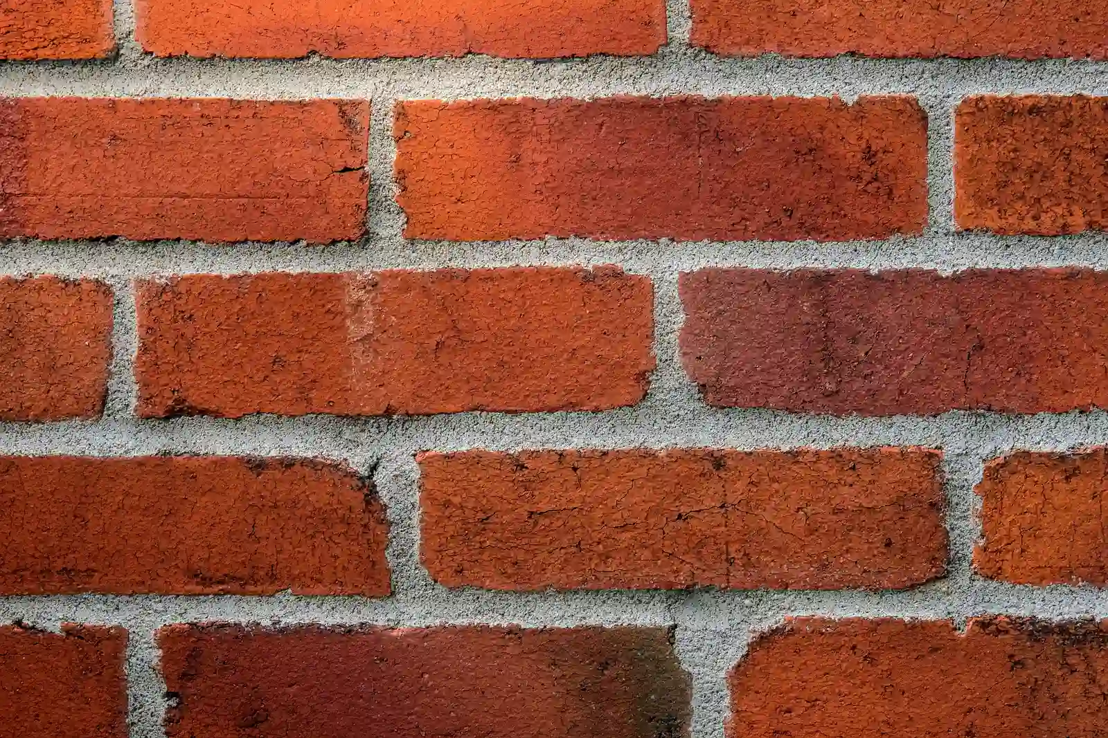 Mason hand-tooling a fresh mortar joint between brick courses