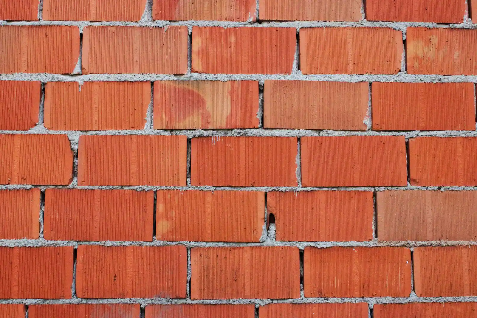 Clean new red brick wall installation with fresh mortar joints