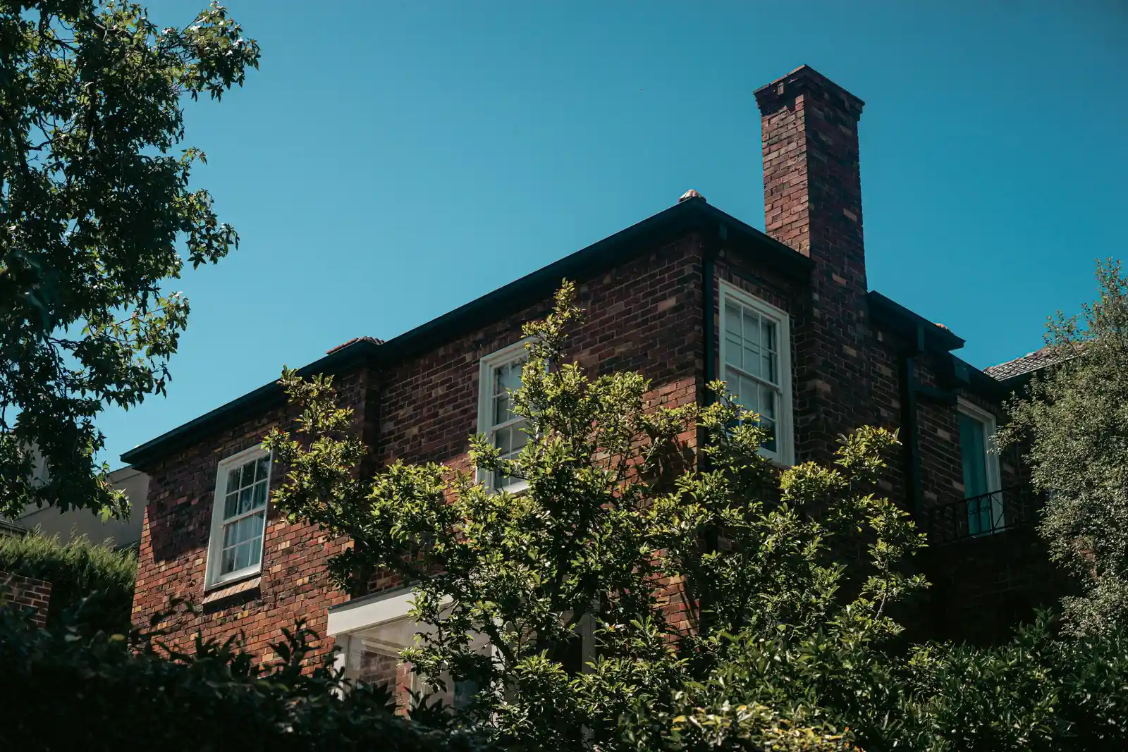 After — finished chimney rebuild with clean brick and blue sky