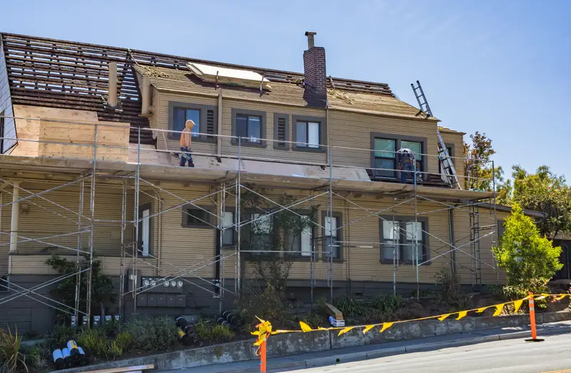 Crew rebuilding a brick chimney and roofline on a Chicagoland home