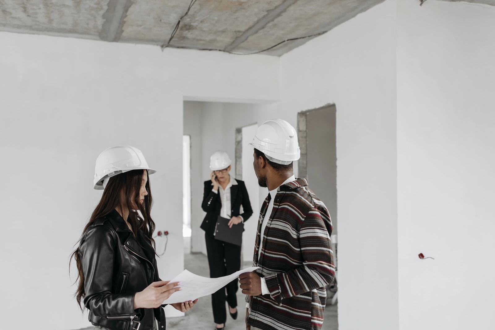 Our Mission — GC, architect, and client reviewing plans on a new commercial construction site