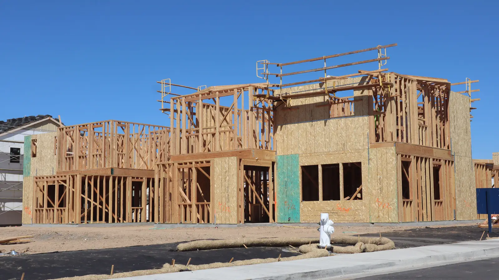 Before — wood-framed new home construction site ready for masonry