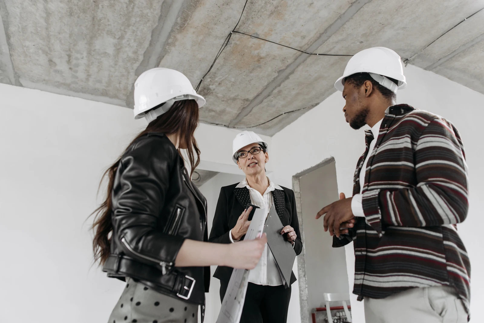 Our Mission — builder and homeowners reviewing plans on a new construction site