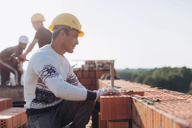 In-house mason crew laying brick together on a new custom home build