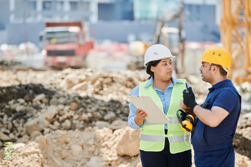 AMS site supervisor and mason reviewing a stone facade project on site