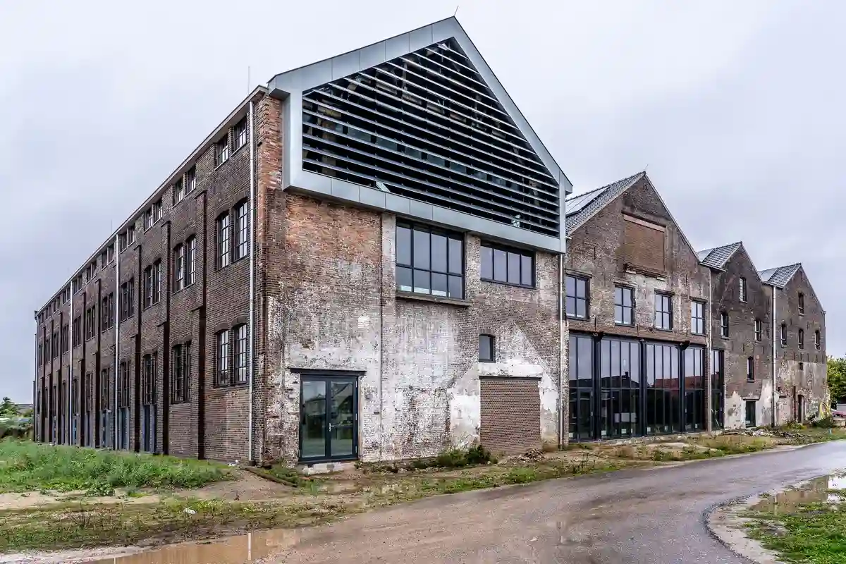 Before: Primary facade — plain concrete wall clad with anchored natural stone veneer panels