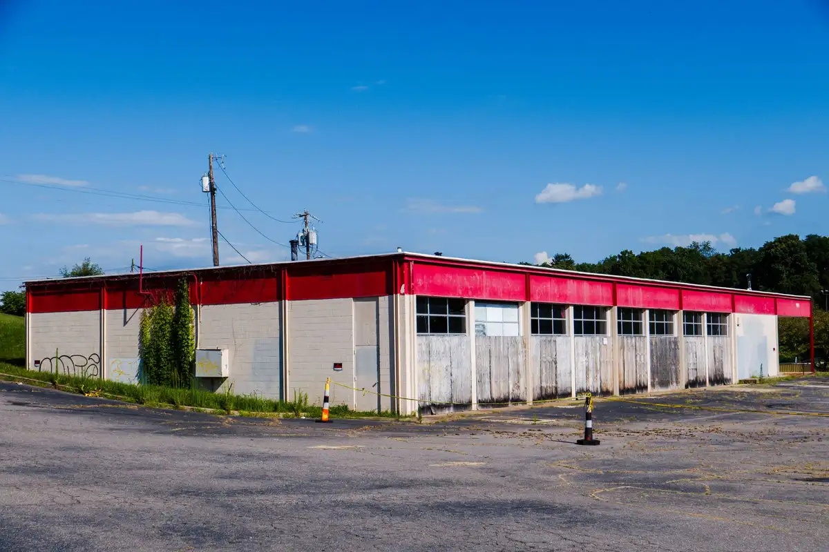 Before: Primary facade — plain concrete wall clad with anchored natural stone veneer panels